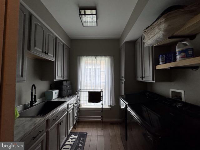 kitchen featuring gray cabinets, sink, and light wood-type flooring