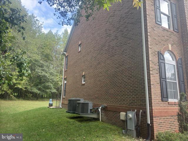 view of home's exterior with cooling unit and a lawn