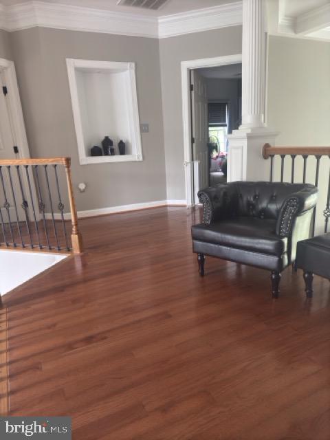 living area featuring crown molding and dark hardwood / wood-style flooring