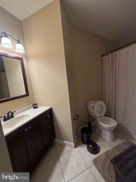 bathroom featuring walk in shower, vanity, toilet, and tile patterned floors