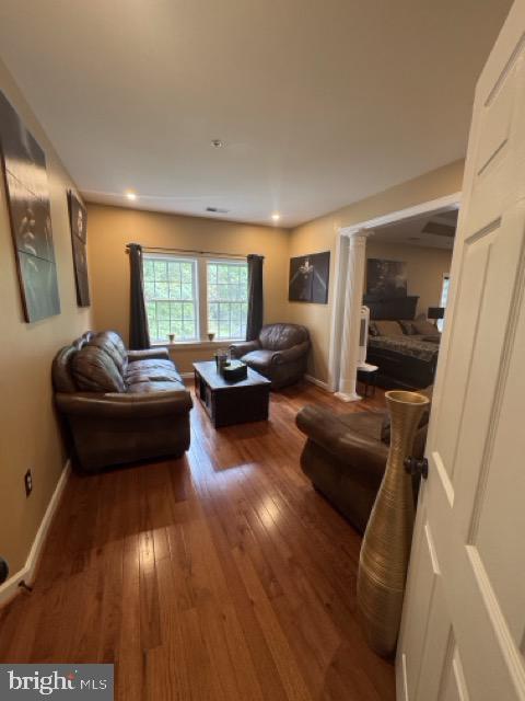 living room with ornate columns and wood-type flooring