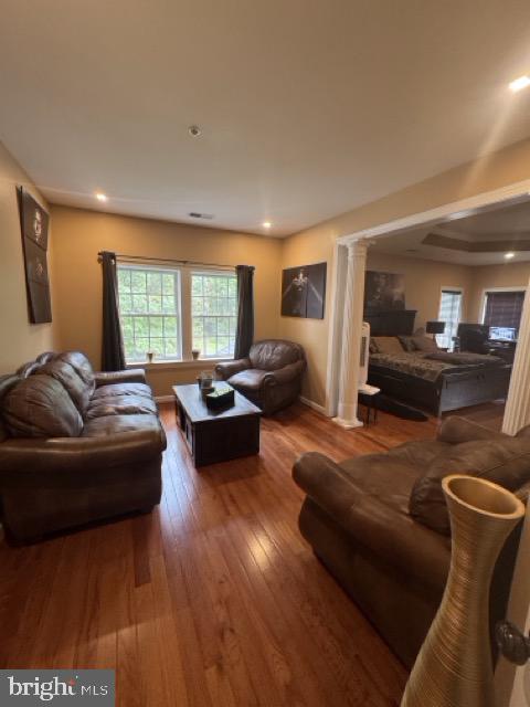 living room featuring ornate columns and hardwood / wood-style flooring