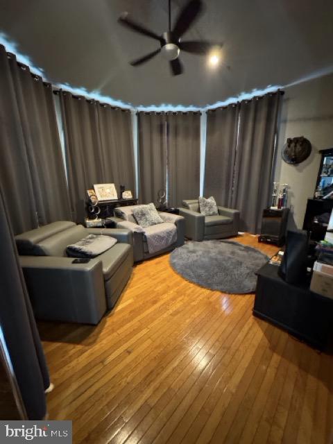 living room featuring ceiling fan and hardwood / wood-style flooring