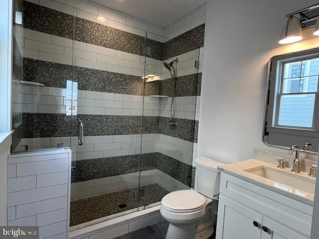 bathroom featuring vanity, toilet, and an enclosed shower