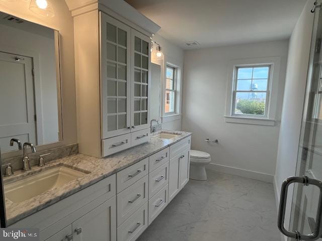 bathroom featuring plenty of natural light, vanity, and toilet