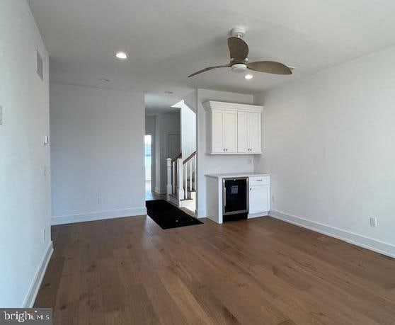 unfurnished living room with ceiling fan and dark hardwood / wood-style floors