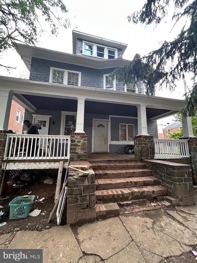 american foursquare style home featuring covered porch