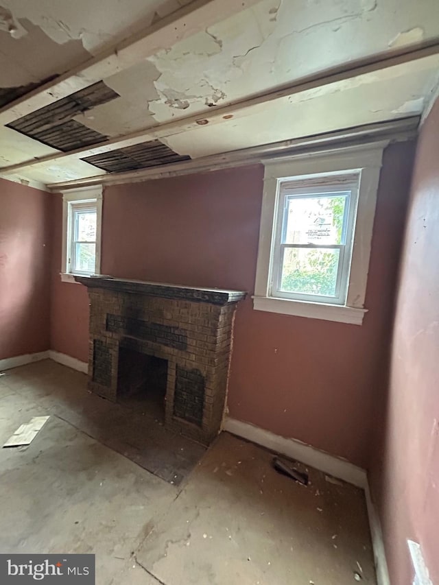 unfurnished living room with a fireplace and baseboards