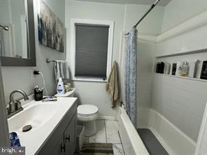 full bathroom with shower / bath combination with curtain, vanity, and toilet