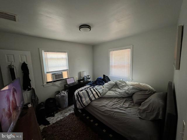 bedroom with cooling unit and multiple windows