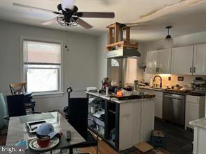 kitchen with ceiling fan, white cabinets, a center island, and stainless steel dishwasher