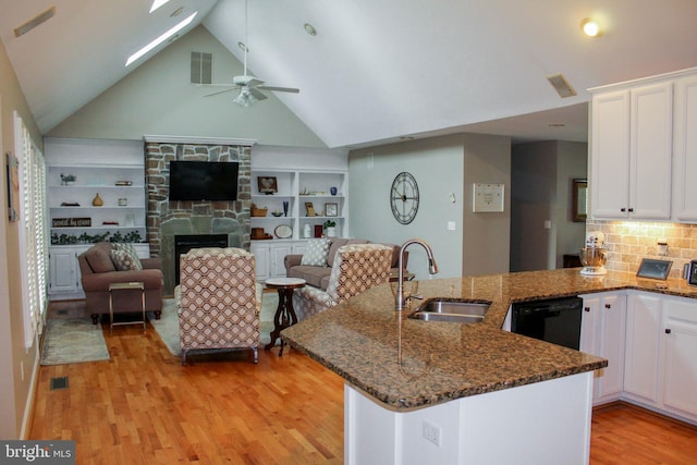 kitchen with white cabinets, kitchen peninsula, dishwasher, light hardwood / wood-style flooring, and sink