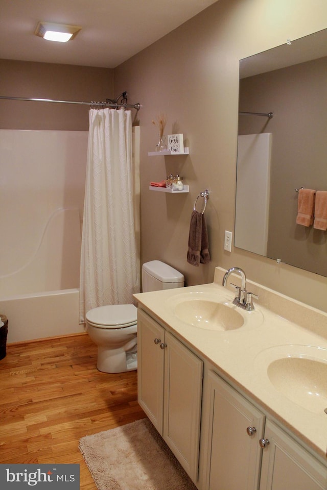 full bathroom featuring shower / tub combo with curtain, vanity, hardwood / wood-style floors, and toilet