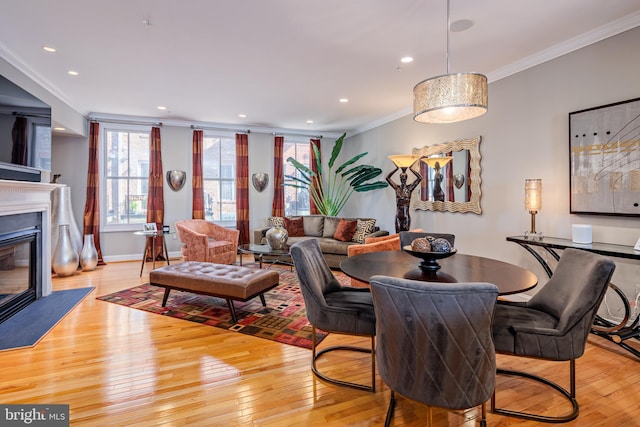 dining room with light hardwood / wood-style flooring and ornamental molding