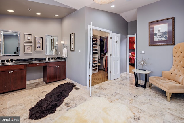 bathroom with vanity and lofted ceiling