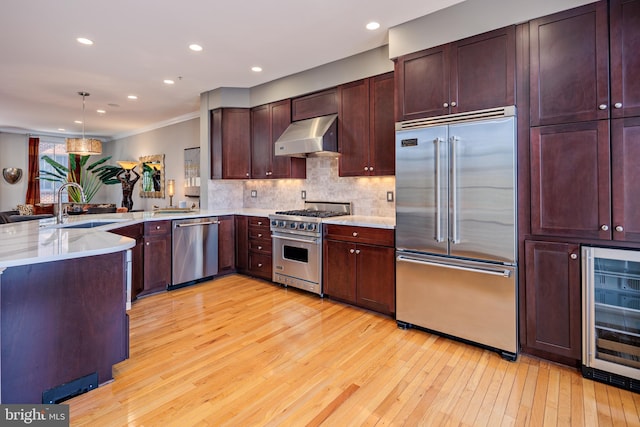 kitchen featuring light hardwood / wood-style flooring, sink, range hood, and high end appliances