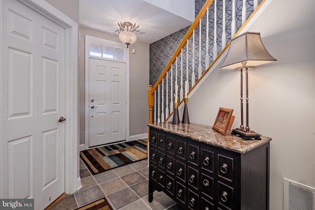 foyer entrance featuring tile patterned flooring and a chandelier