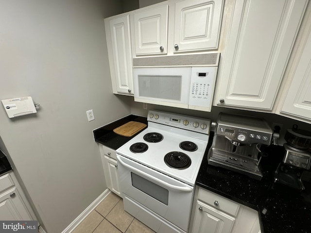 kitchen with white appliances, white cabinets, and light tile patterned flooring