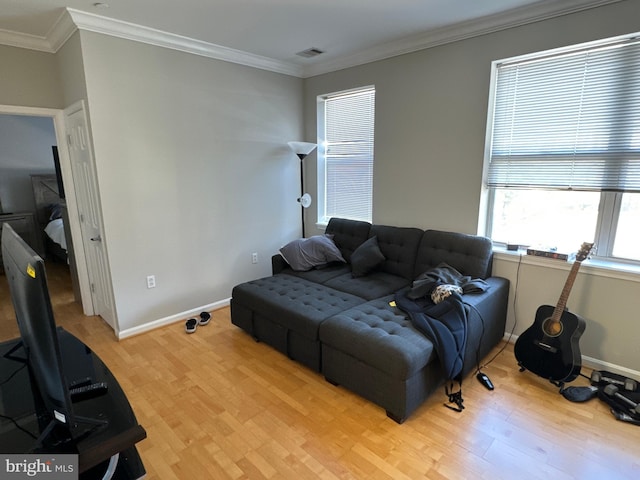 living room with light wood-type flooring and ornamental molding