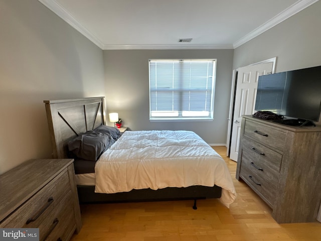 bedroom with light wood-type flooring and crown molding