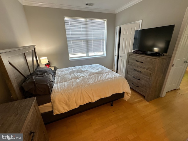 bedroom featuring ornamental molding and light hardwood / wood-style flooring