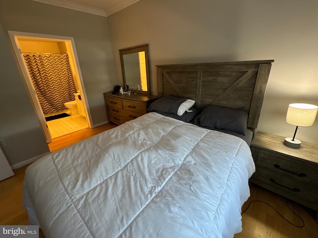 bedroom with ensuite bath, crown molding, and light hardwood / wood-style flooring