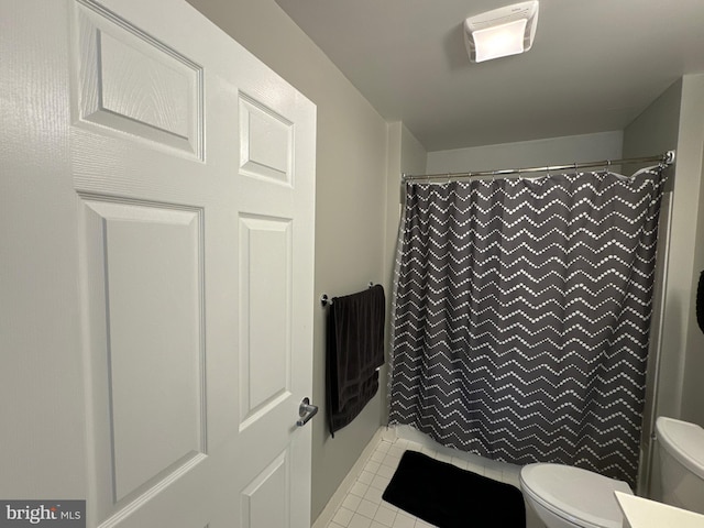 bathroom featuring toilet, tile patterned floors, and a shower with shower curtain