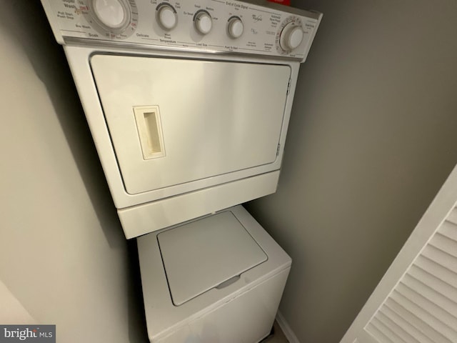 clothes washing area featuring stacked washer and clothes dryer