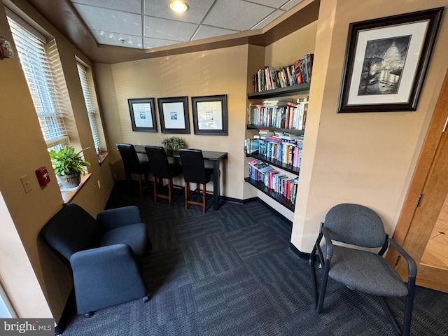 carpeted home office featuring a paneled ceiling