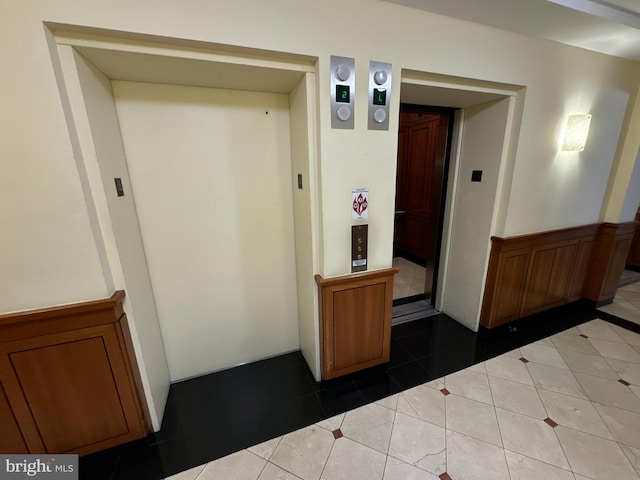 corridor with tile patterned floors and elevator