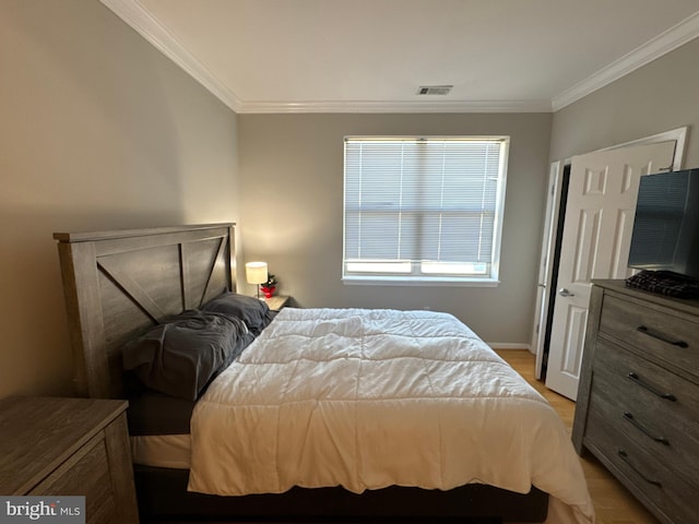 bedroom with ornamental molding and light hardwood / wood-style flooring