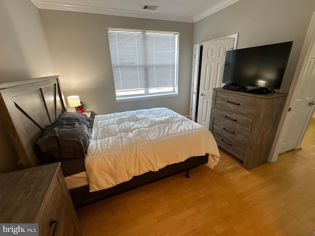 bedroom featuring ornamental molding and light hardwood / wood-style floors