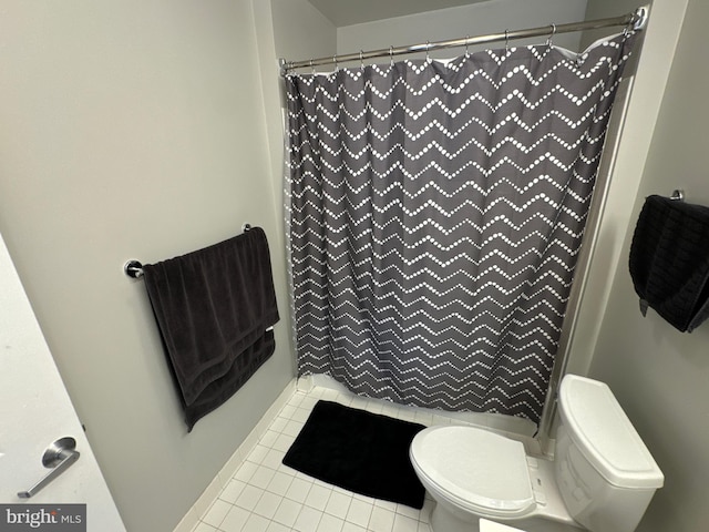 bathroom with curtained shower, toilet, and tile patterned flooring