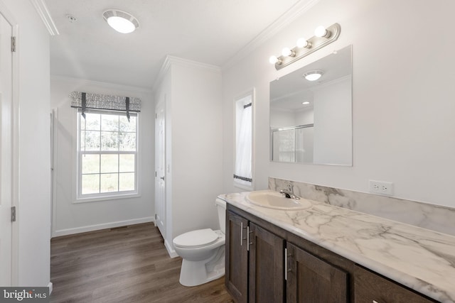 bathroom featuring toilet, wood-type flooring, crown molding, vanity, and an enclosed shower