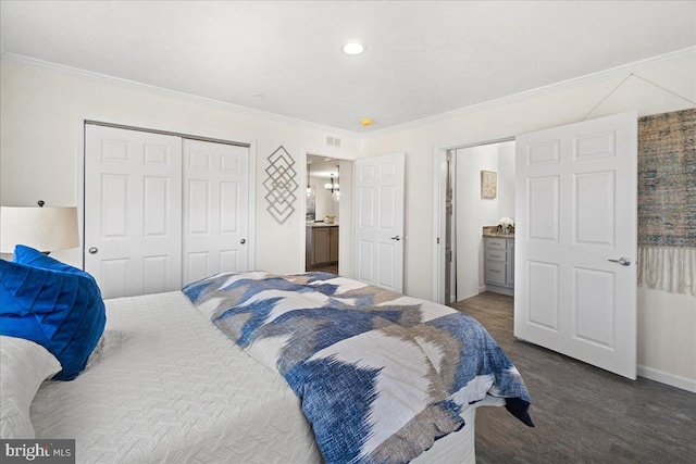 bedroom featuring dark carpet, ornamental molding, a closet, and ensuite bath