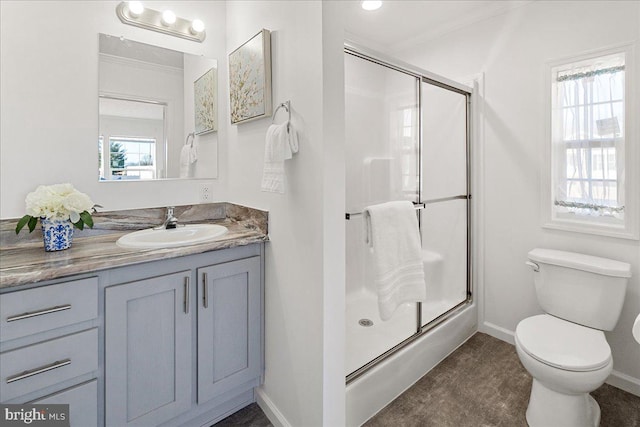 bathroom featuring toilet, crown molding, a healthy amount of sunlight, and vanity