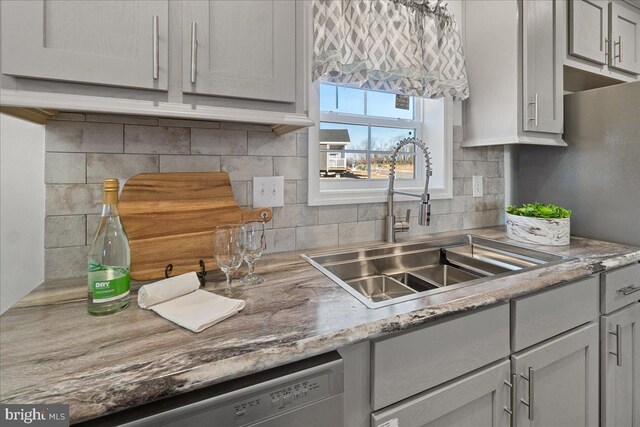 kitchen with sink, decorative backsplash, gray cabinetry, and dishwasher