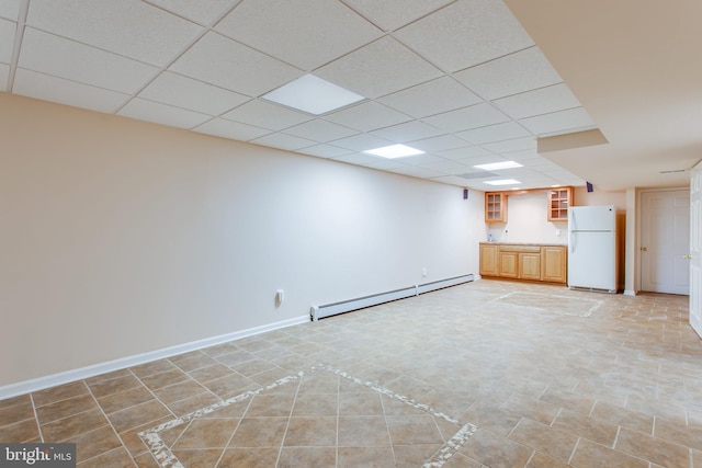 unfurnished living room with a baseboard heating unit, light tile patterned floors, and a paneled ceiling