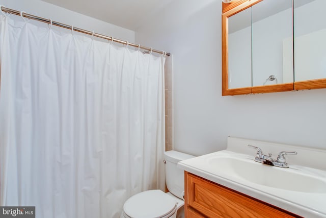 bathroom featuring curtained shower, vanity, and toilet