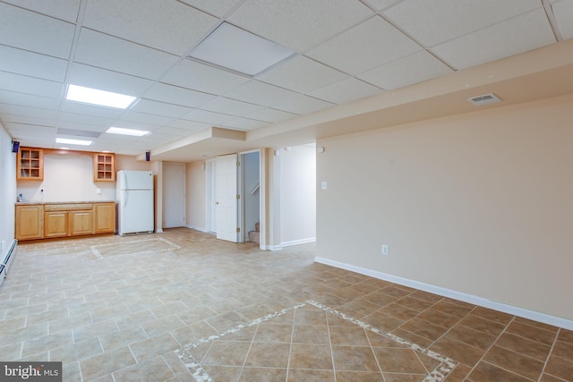 interior space with a paneled ceiling and light tile patterned floors