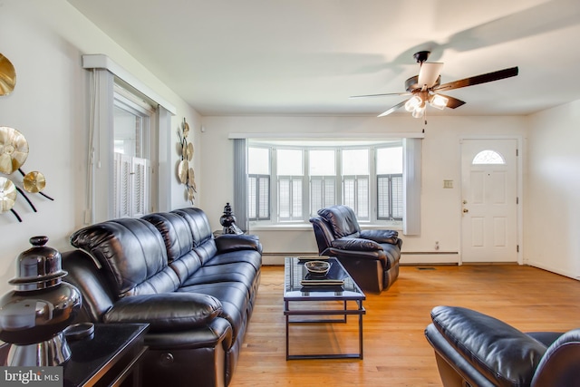 living room featuring ceiling fan, light hardwood / wood-style flooring, and baseboard heating