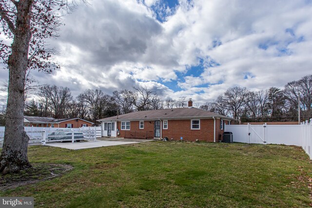 back of property with a lawn, a patio, and cooling unit