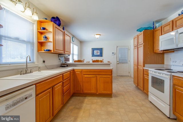 kitchen featuring white appliances, sink, and kitchen peninsula