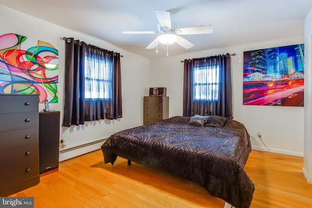 bedroom featuring a baseboard heating unit, wood-type flooring, and ceiling fan