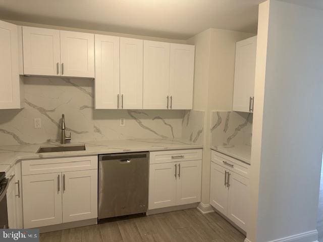 kitchen with dark hardwood / wood-style floors, stainless steel dishwasher, white cabinetry, and sink