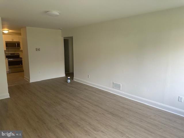 unfurnished room with hardwood / wood-style flooring