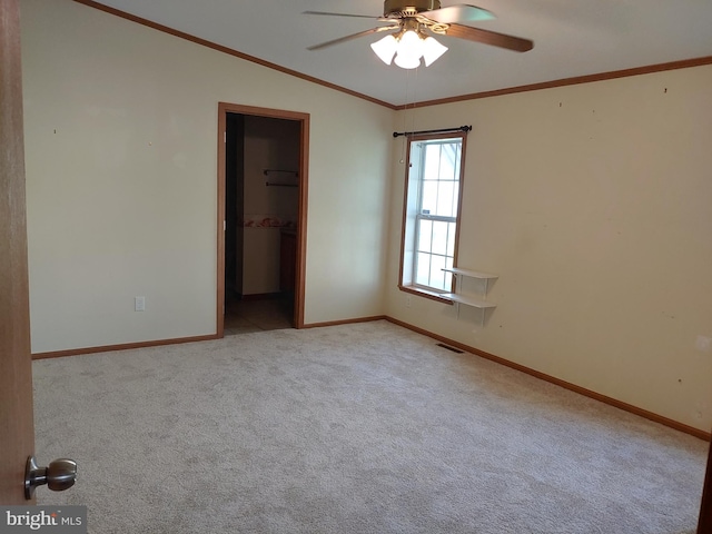 carpeted spare room with ceiling fan, lofted ceiling, and ornamental molding