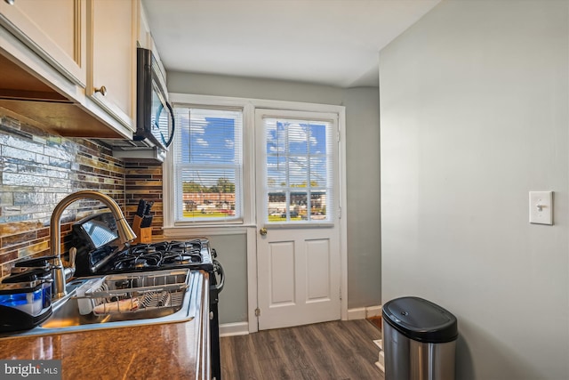 kitchen featuring decorative backsplash, sink, dark wood-type flooring, and stainless steel range with gas stovetop