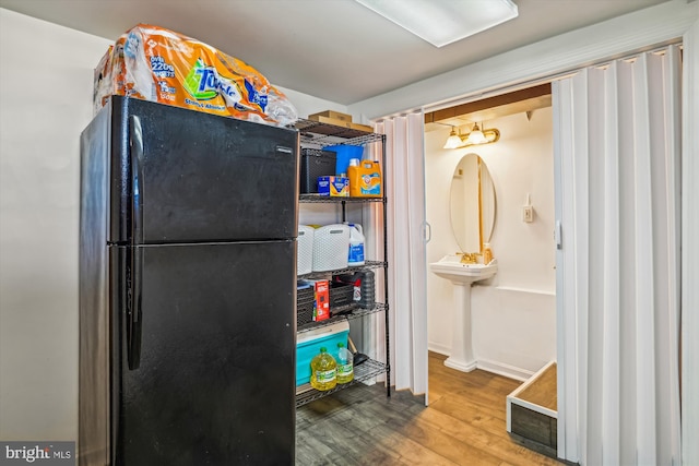 kitchen with black refrigerator and wood-type flooring