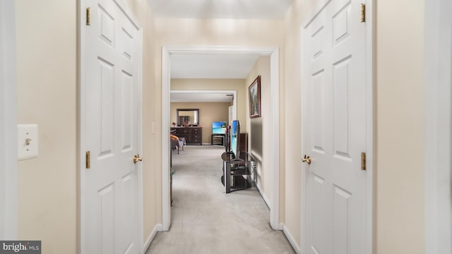 hall with light colored carpet